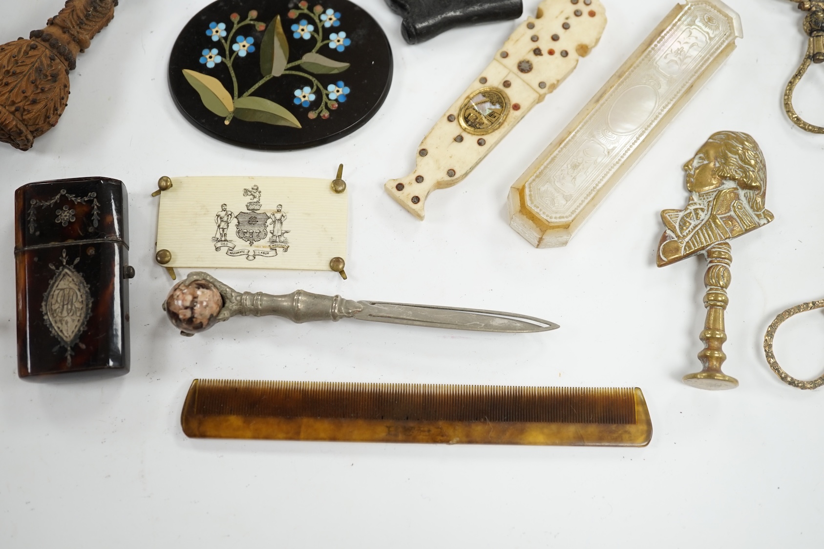 Miscellaneous objects of vertu including a pair of carved wood boots, an inlaid tortoiseshell needle case, a carved mother of pearl box and a pietra dura oval floral panel, largest 12.5cm in length. Condition - mostly fa